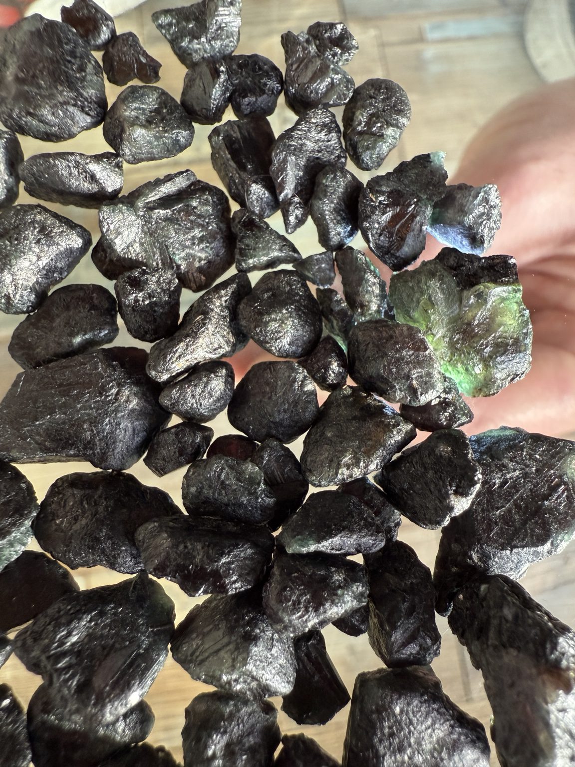 Close view of flattened alexandrite specimens from Bahia with surface ridges and a translucent green edge